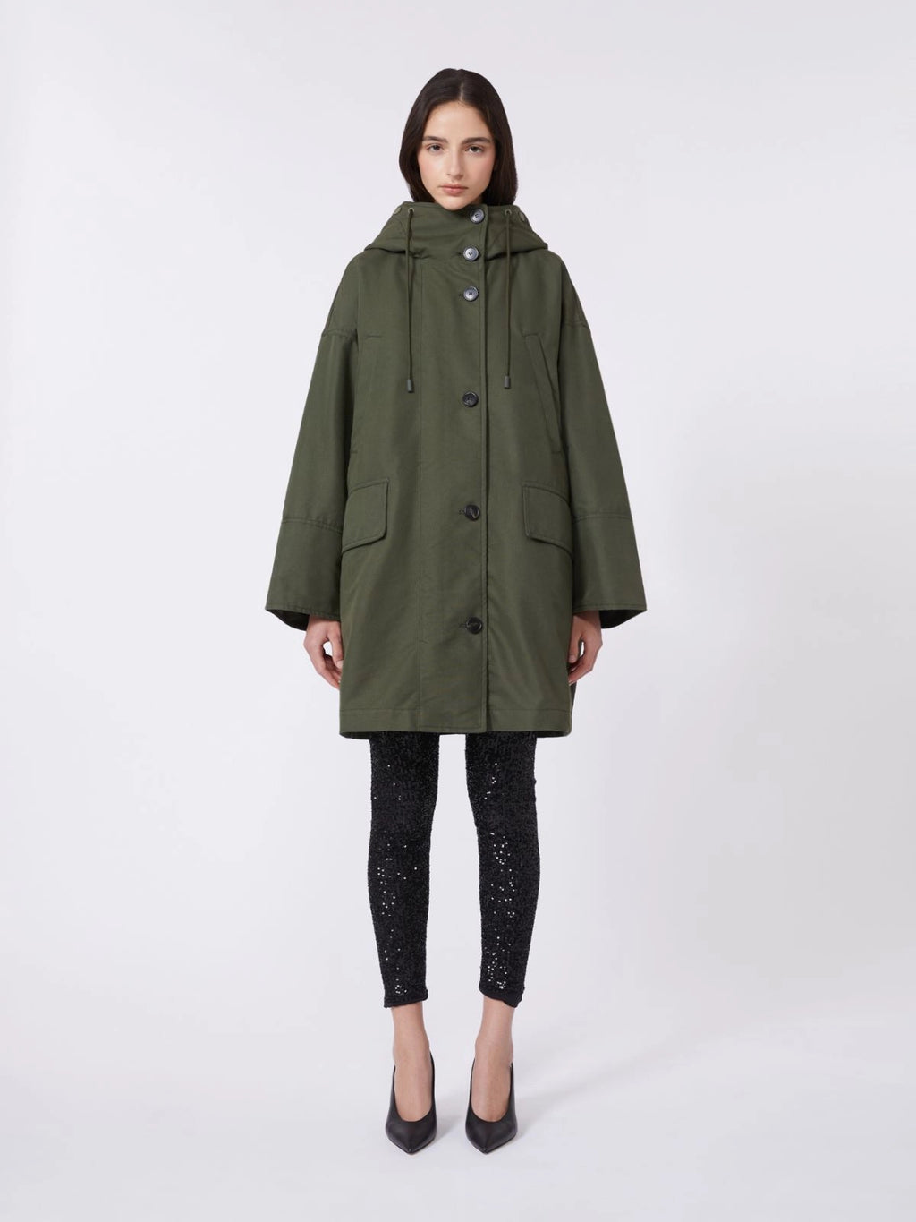 Woman wearing a green coat on a white background