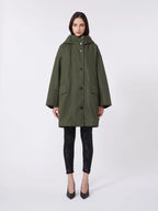 Woman wearing a green coat on a white background