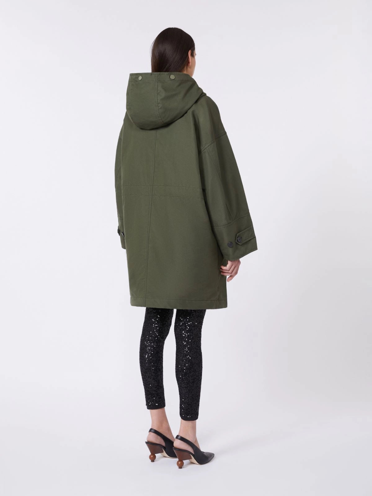 Person wearing a green raincoat on a white background