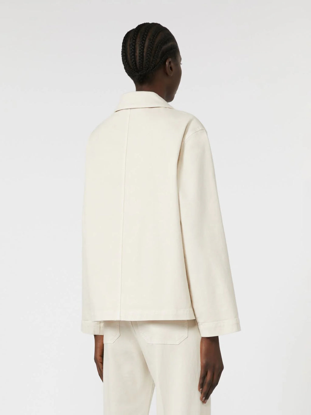 Person wearing a white suit on a plain background