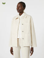 Woman wearing a cream-colored suit on a white background
