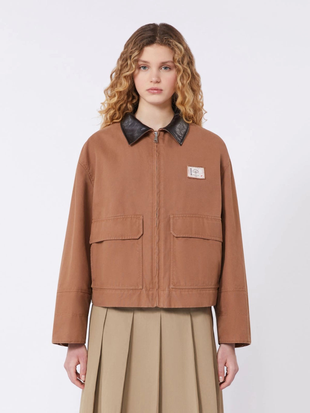 Woman wearing a brown jacket with a black collar on a white background
