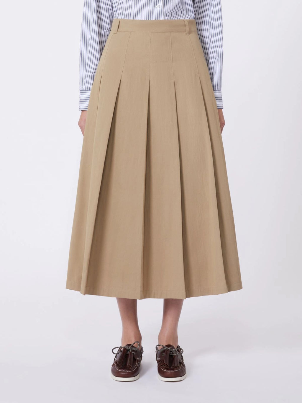 Person wearing a beige pleated skirt on a white background