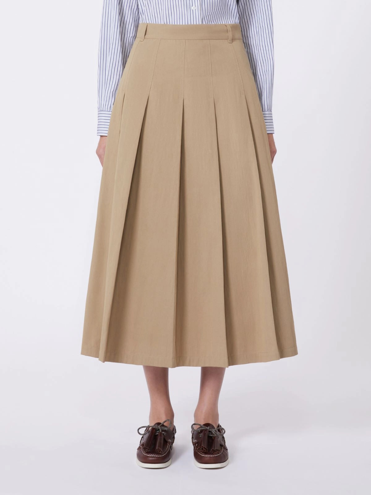 Person wearing a beige pleated skirt on a white background