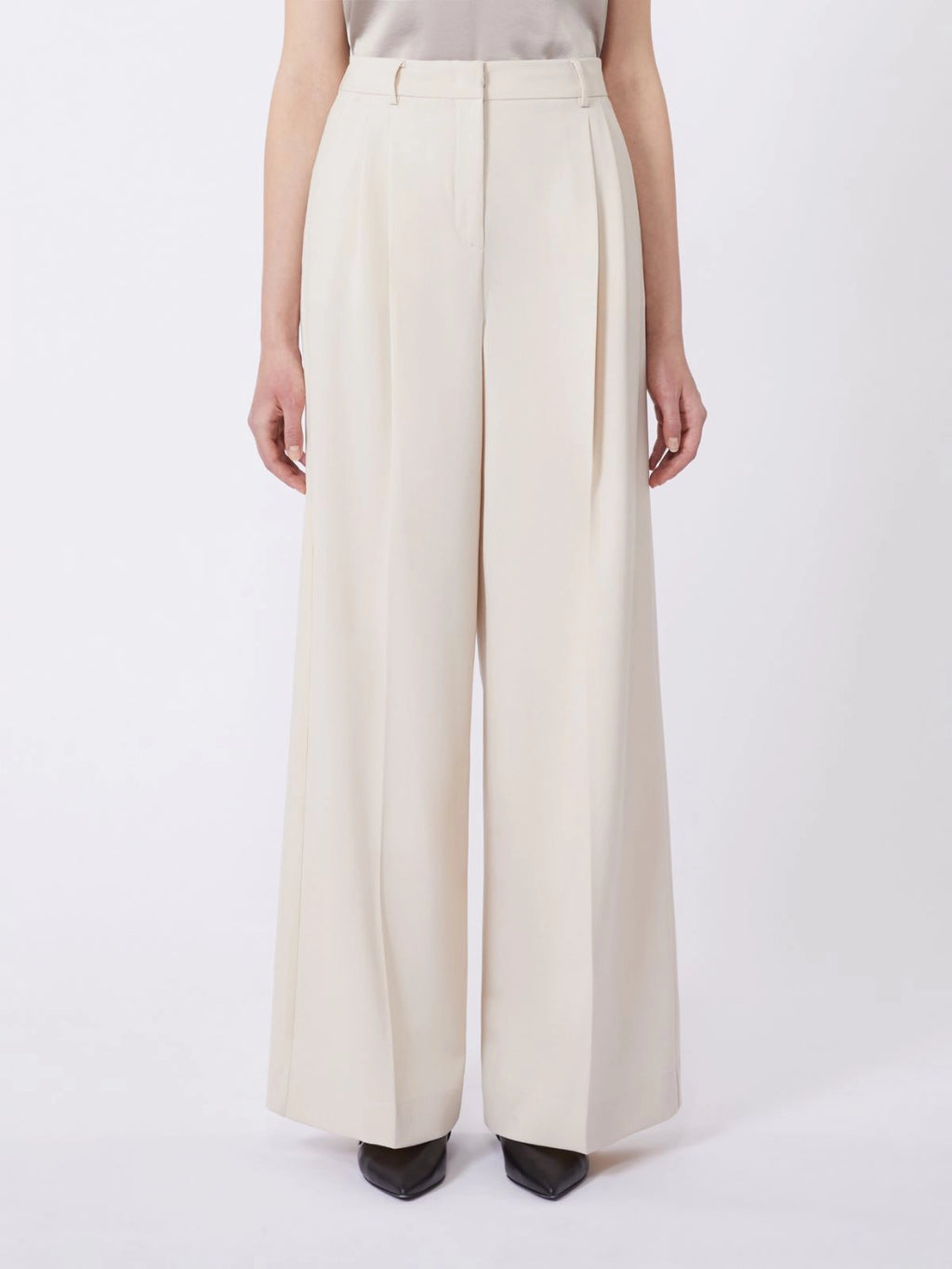 Person wearing white wide-leg pants on a white background