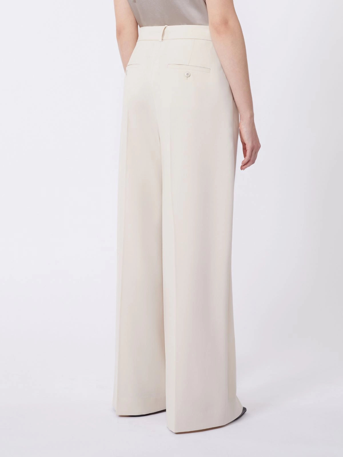 Beige wide-leg pants worn by a person on a white background