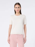 Woman wearing a white t-shirt and pink pants on a white background