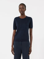 Person wearing a navy blue outfit on a white background