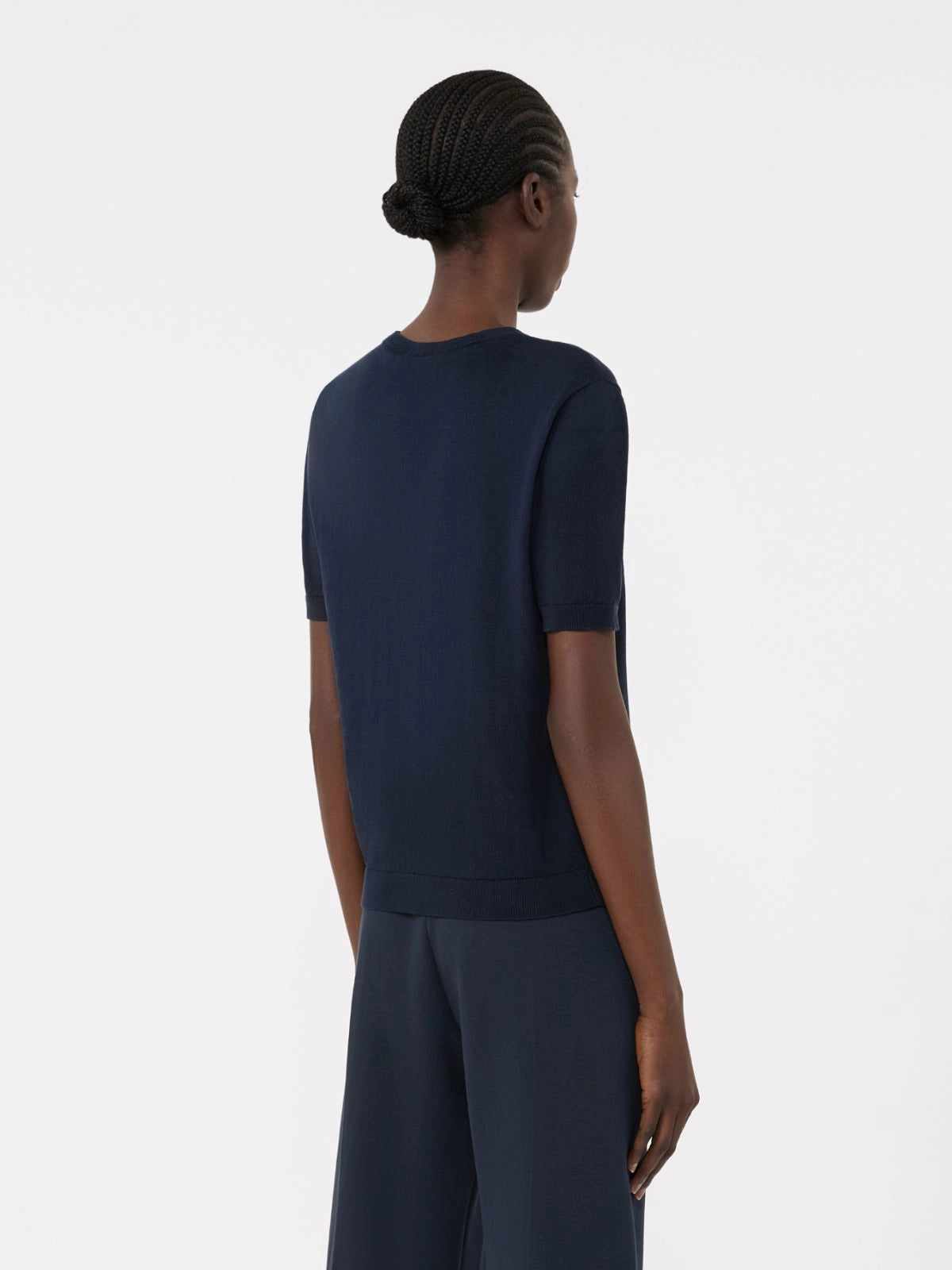 Person wearing a navy blue outfit on a white background