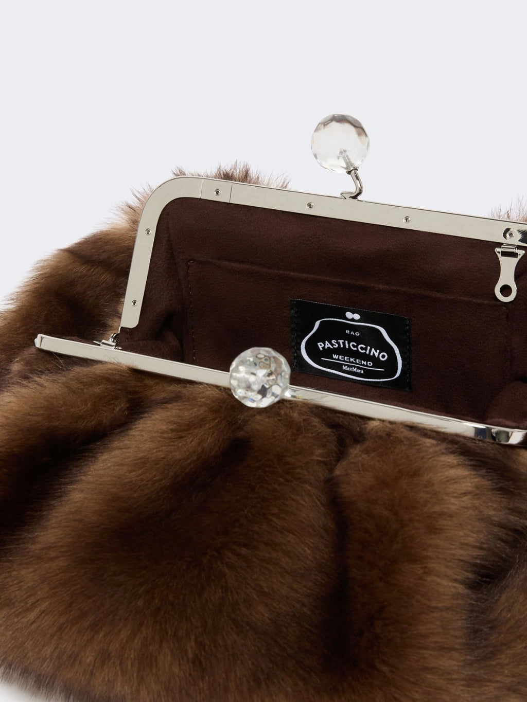 Brown fur clutch with a visible brand label on a white background