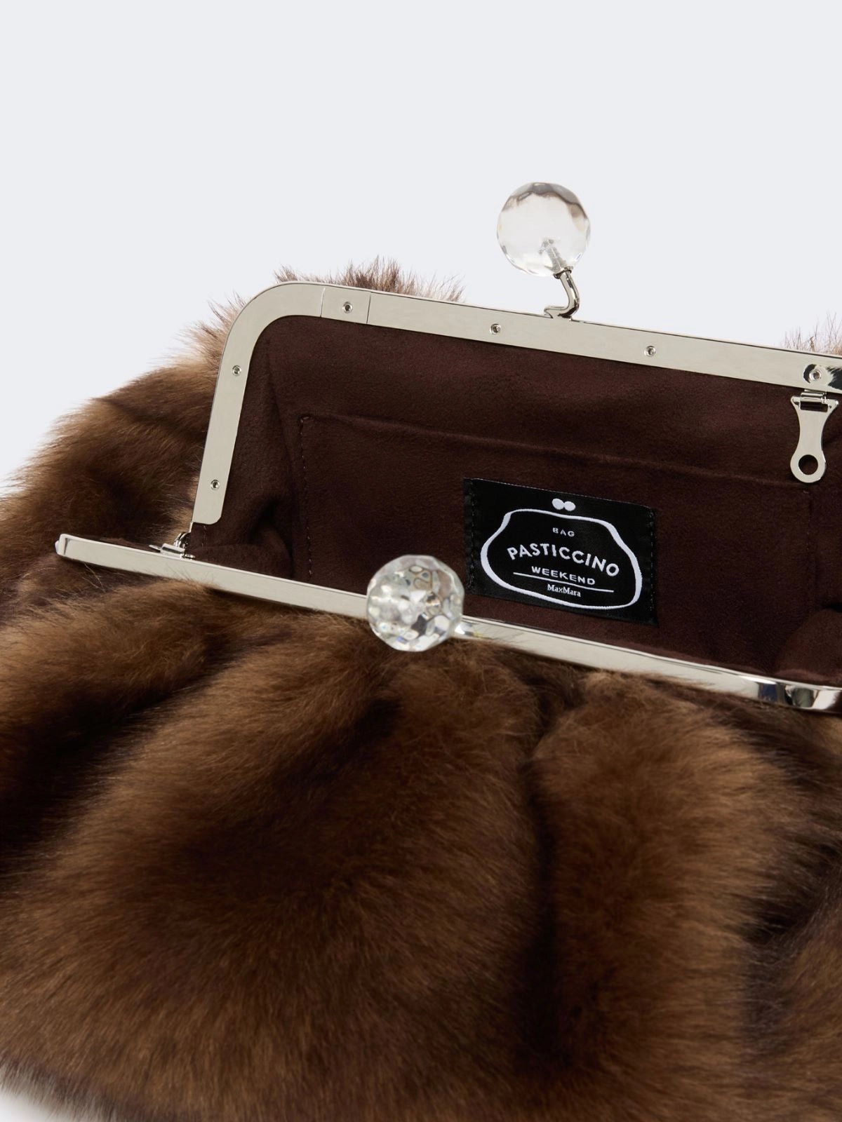 Brown fur clutch with a visible brand label on a white background