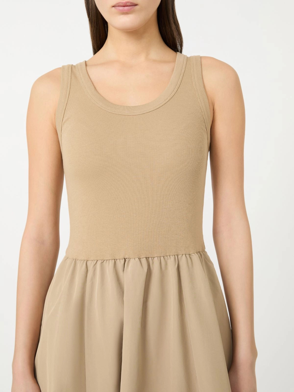 Beige sleeveless dress worn by a model on a white background