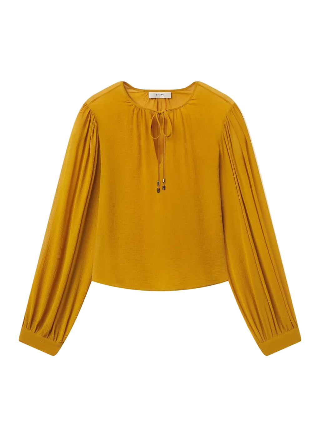 A mustard yellow long-sleeve blouse with a round neckline, front tie detail, and gathered sleeves, shown flat on a light gray background.