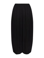 A black pleated midi skirt with a wide leg silhouette and elastic waistband, shown against a plain light gray background.