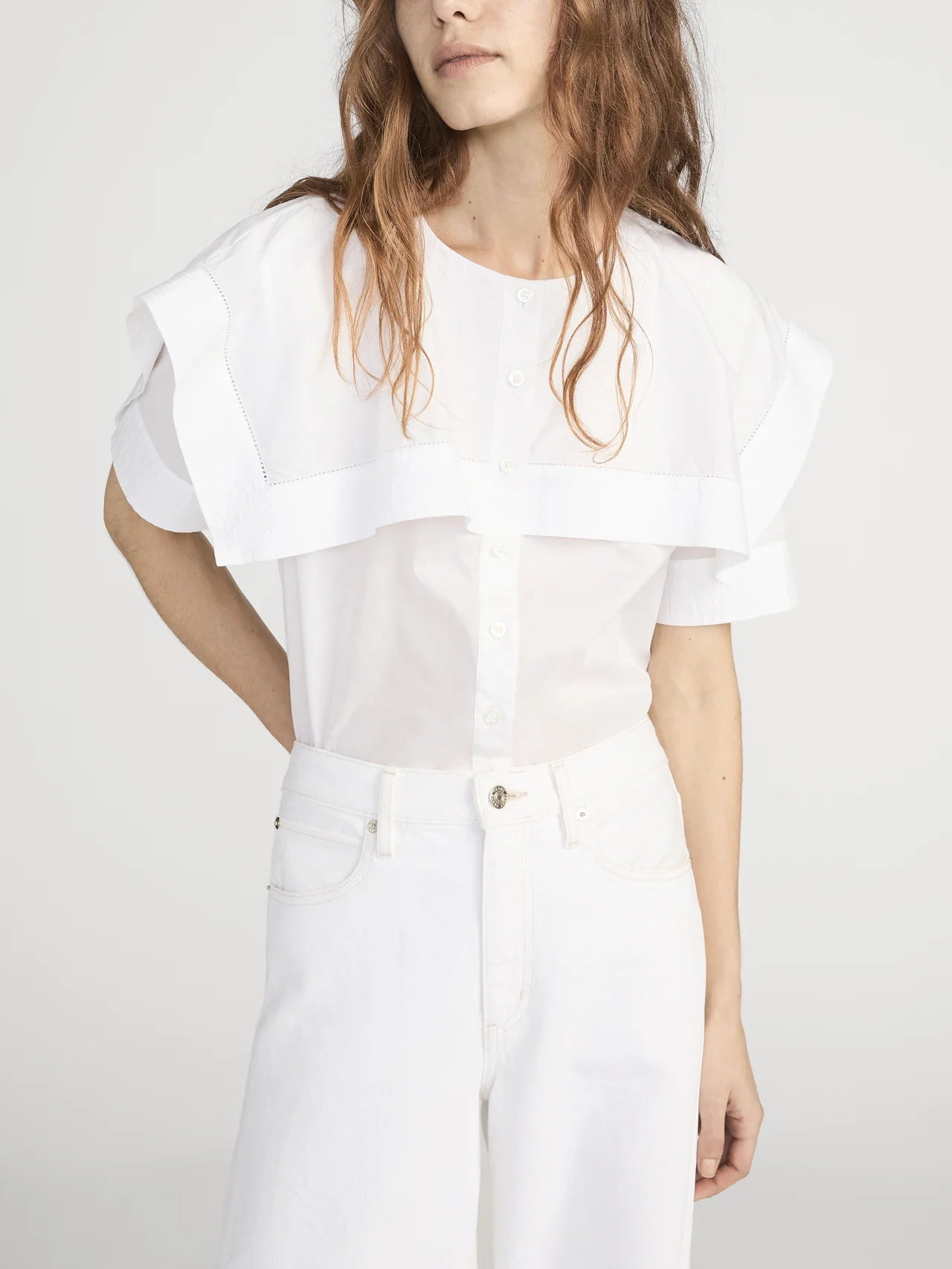 Person wearing a white outfit on a plain background