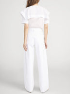 Person wearing a white outfit with a plain background