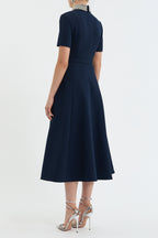 Navy blue dress worn by a model on a white background