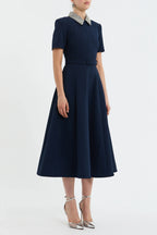 Navy blue dress with a belt and white collar on a white background