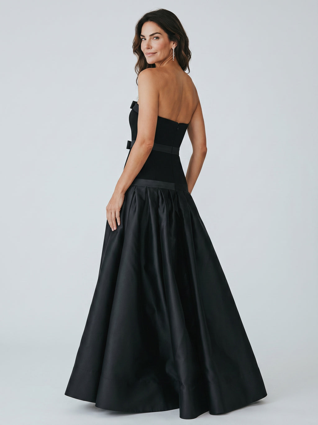 Woman wearing a black evening gown with a white background