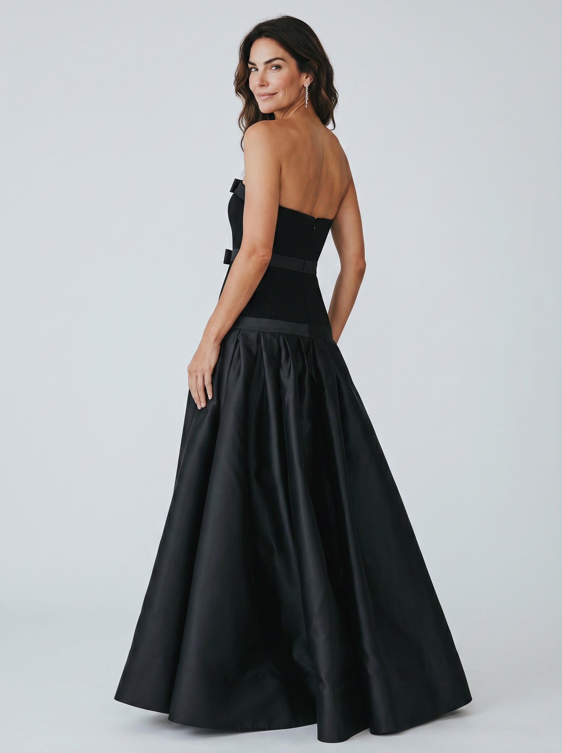 Woman wearing a black evening gown with a white background