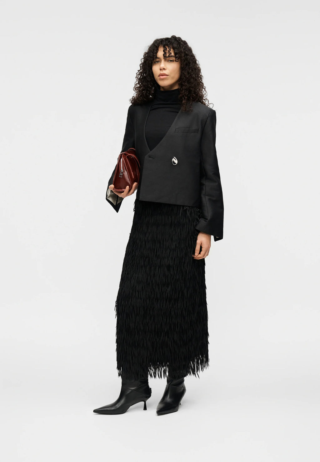 Woman wearing a black outfit with a feathered skirt on a white background