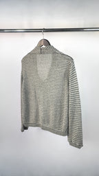 Striped sweater on a hanger against a white background