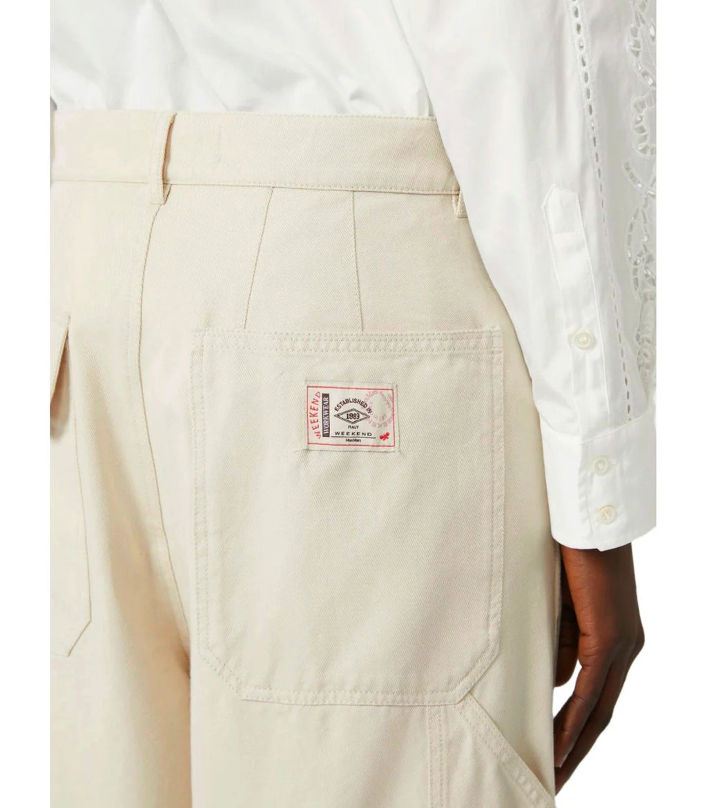 Beige pants with a brand label on the pocket, worn with a white shirt.