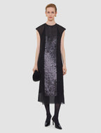 Woman wearing a black dress with a sequined panel on a white background