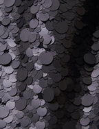 Close-up of black sequins on a dark background