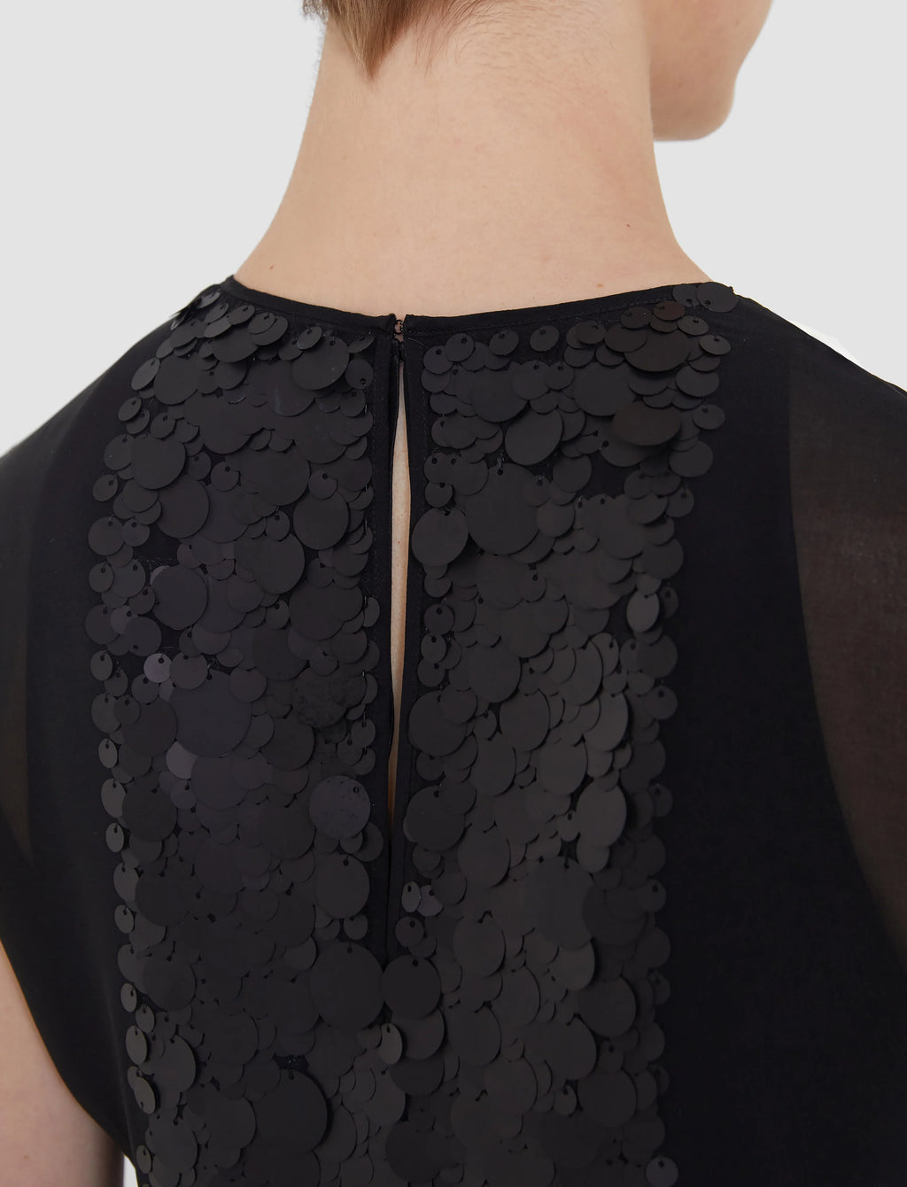 Black sequin top on a plain background