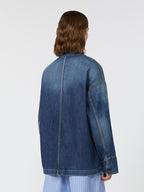 Person wearing a blue denim jacket on a white background