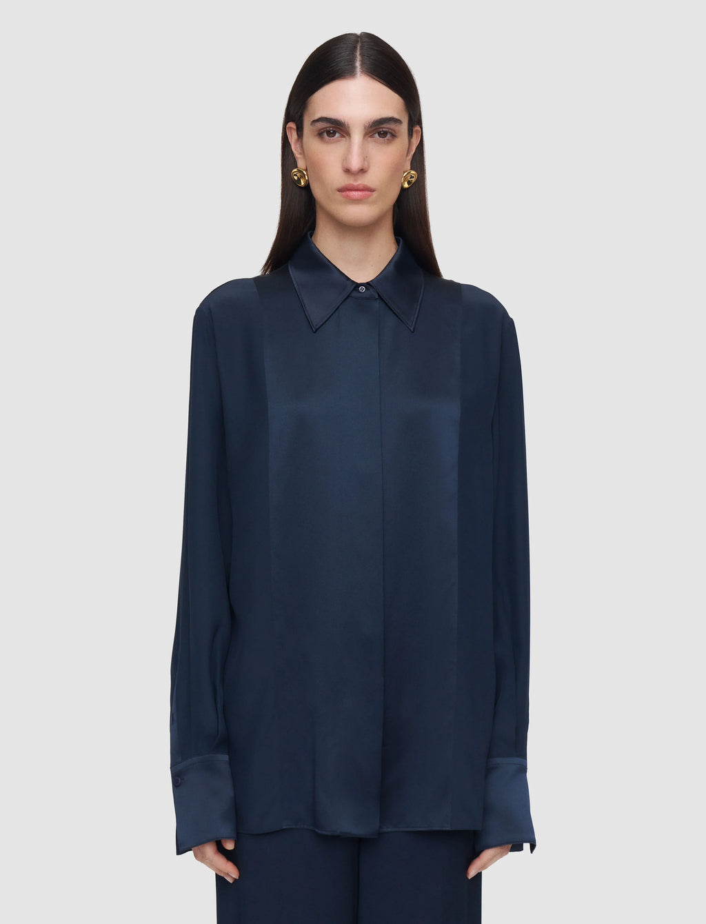 Woman wearing a navy blue shirt against a light gray background