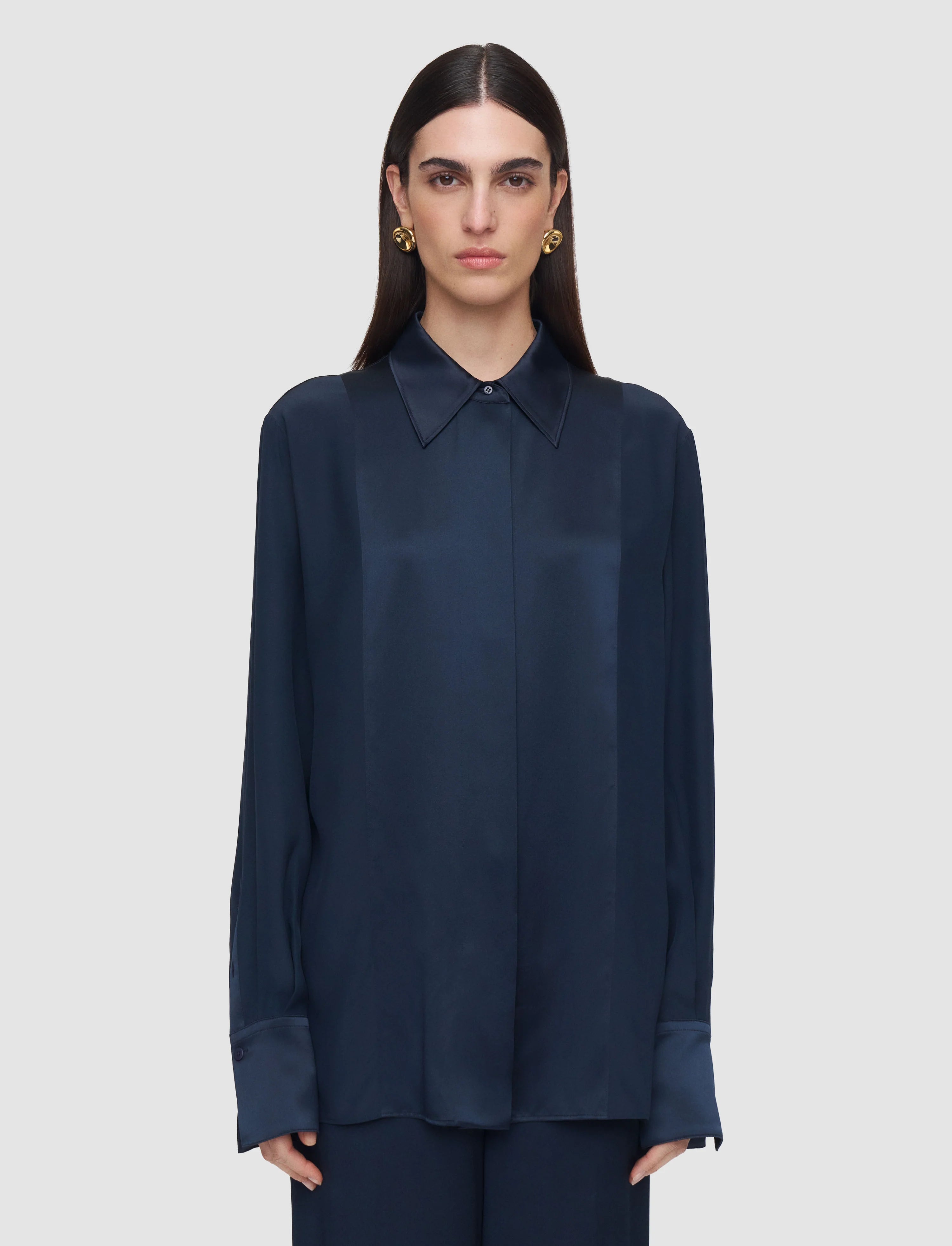 Woman wearing a navy blue shirt against a light gray background