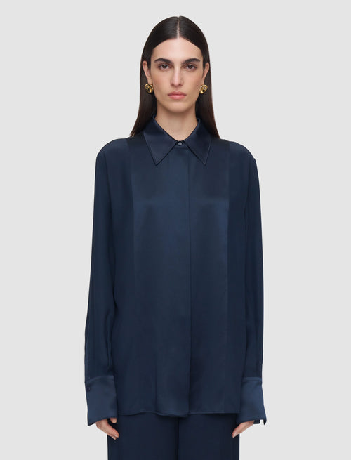 Woman wearing a navy blue shirt against a light gray background