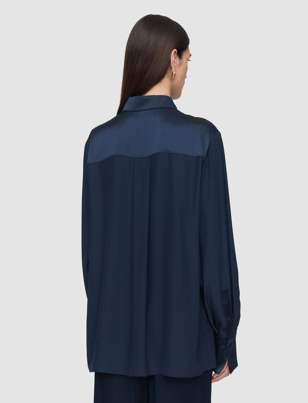 Woman wearing a navy blue shirt on a light gray background