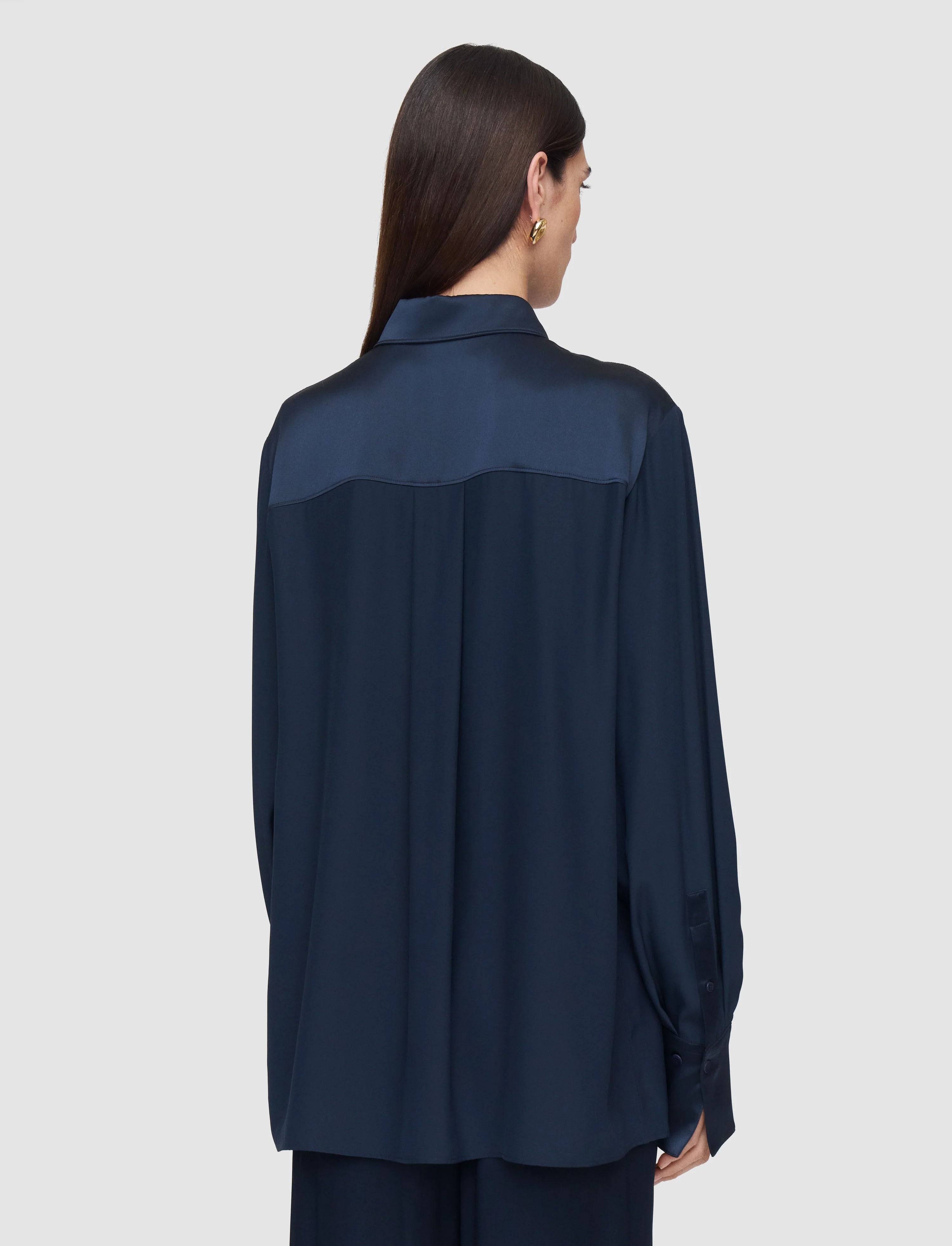 Woman wearing a navy blue shirt on a light gray background