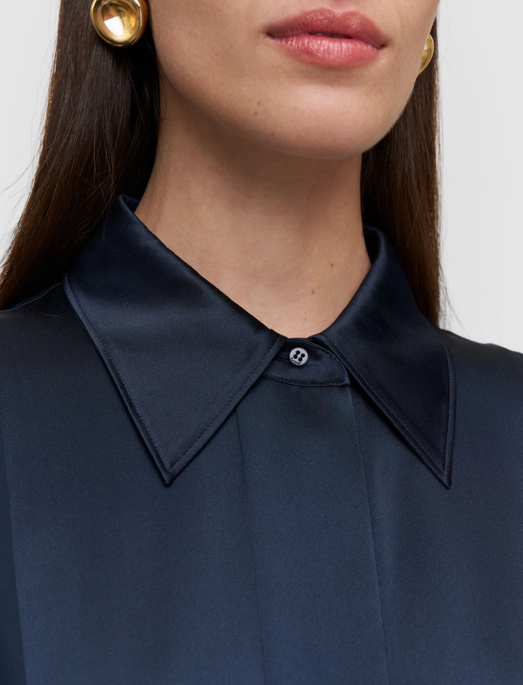 Close-up of a person wearing a navy blue shirt with a collar.