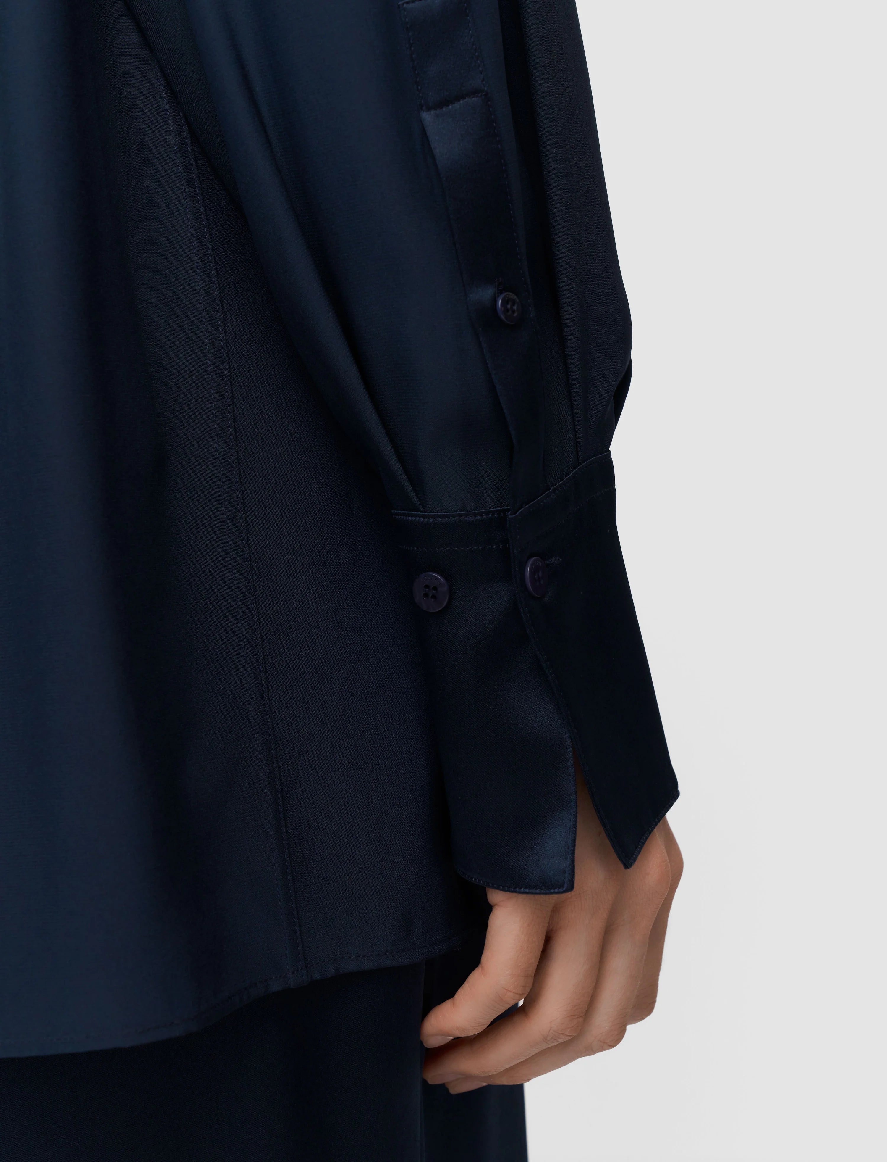 Navy blue blazer with buttons on a light gray background