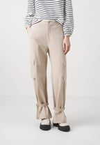 Person wearing beige cargo pants and a striped shirt on a white background
