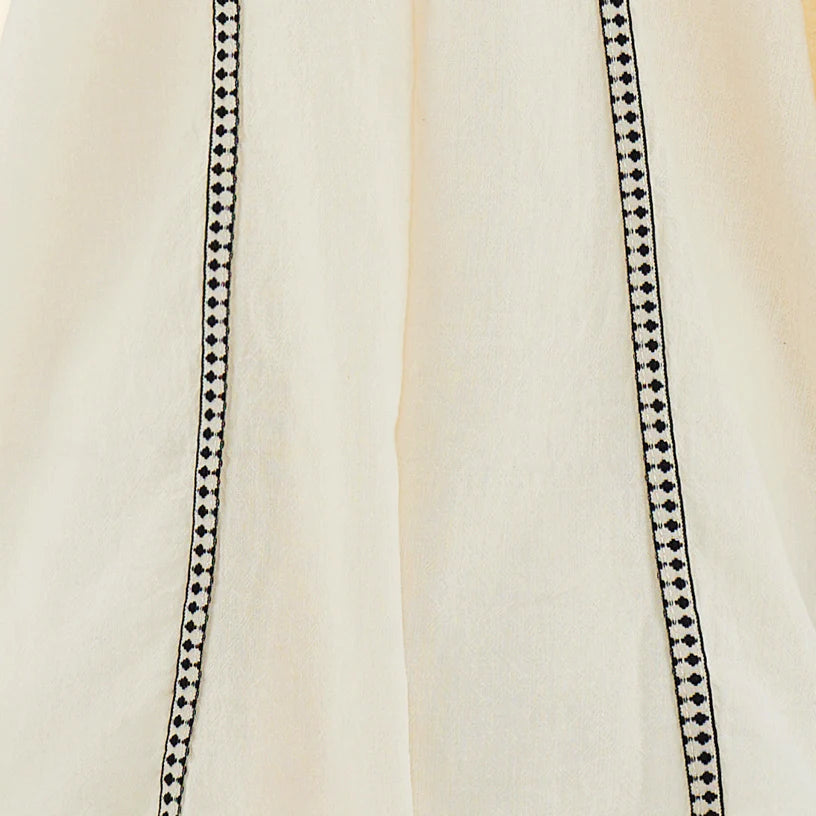 Close-up of a beige fabric with black decorative stitching