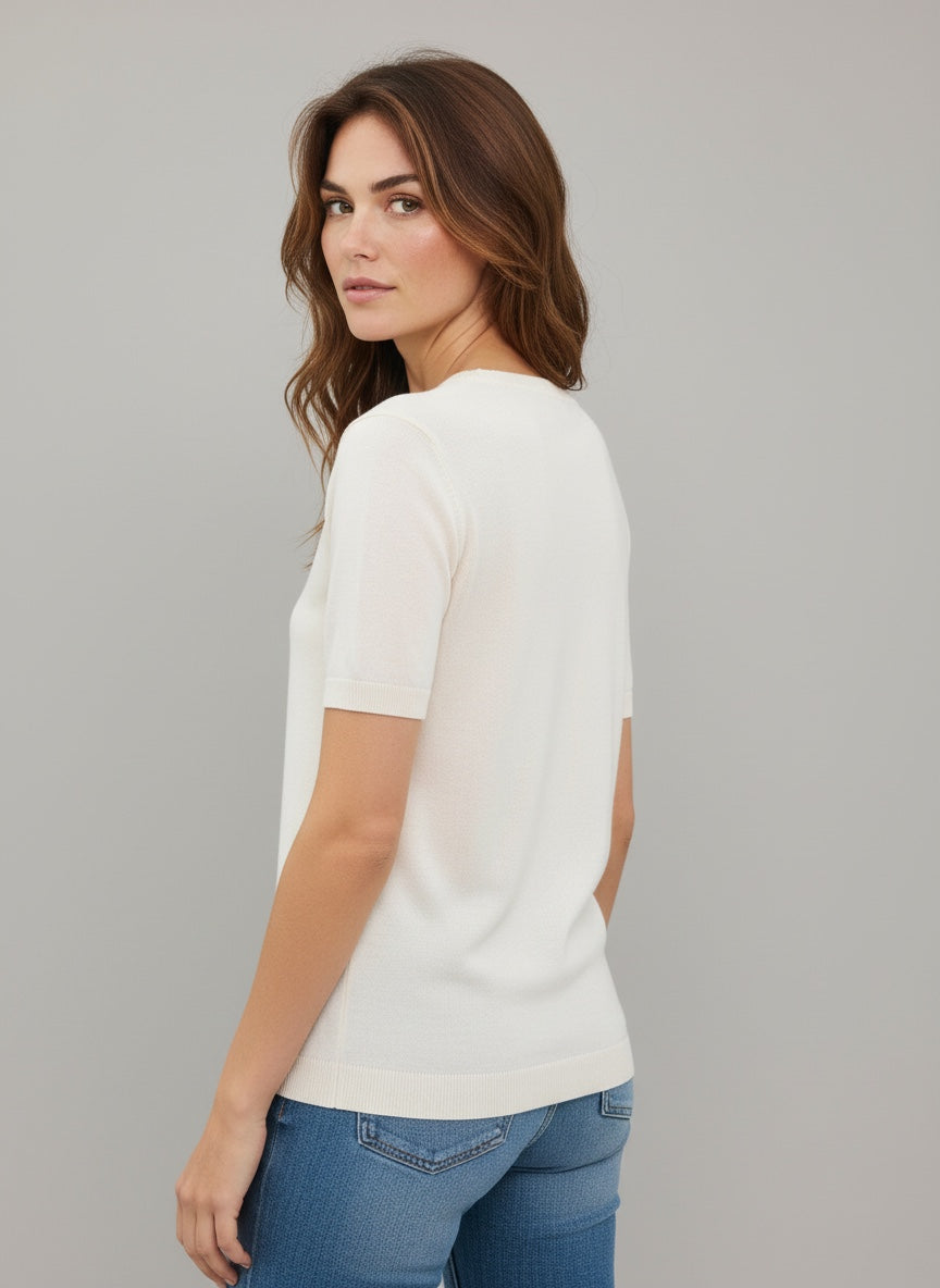 Woman wearing a white t-shirt and blue jeans against a gray background