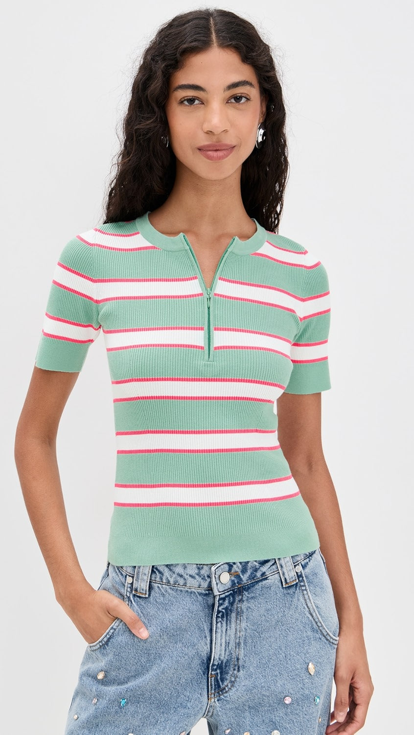 Woman wearing a green and pink striped short-sleeve top with blue jeans on a white background