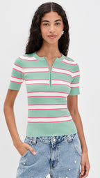 Woman wearing a green and pink striped short-sleeve top with blue jeans on a white background