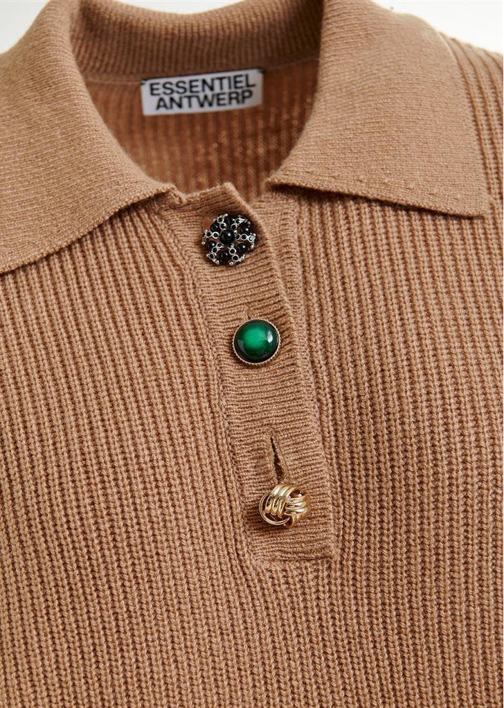 Close-up of a brown ribbed sweater with decorative buttons on a white background, featuring the 'Essentiel Antwerp' brand.