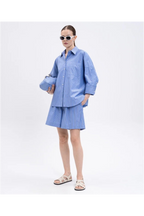 Person wearing a blue checkered outfit with sunglasses on a white background