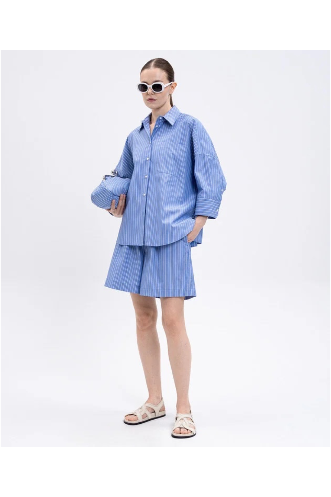 Person wearing a blue checkered outfit with sunglasses on a white background