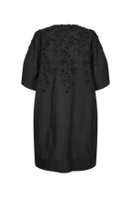 A black short-sleeve tunic dress with 3D floral applique detailing on the back, shown against a plain white background.