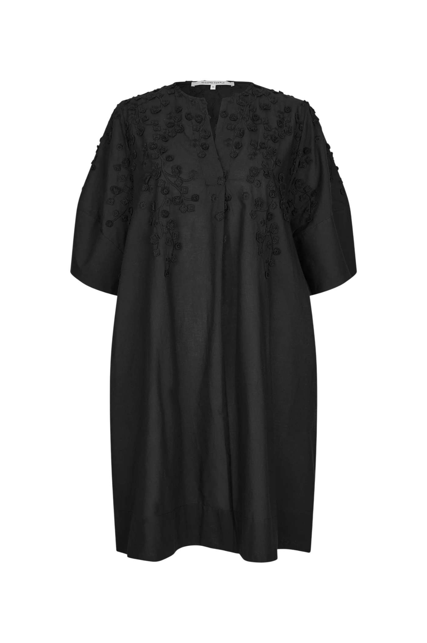 A black short-sleeved tunic dress with intricate floral embroidery and applique detailing on the chest and shoulders, displayed against a solid white background.