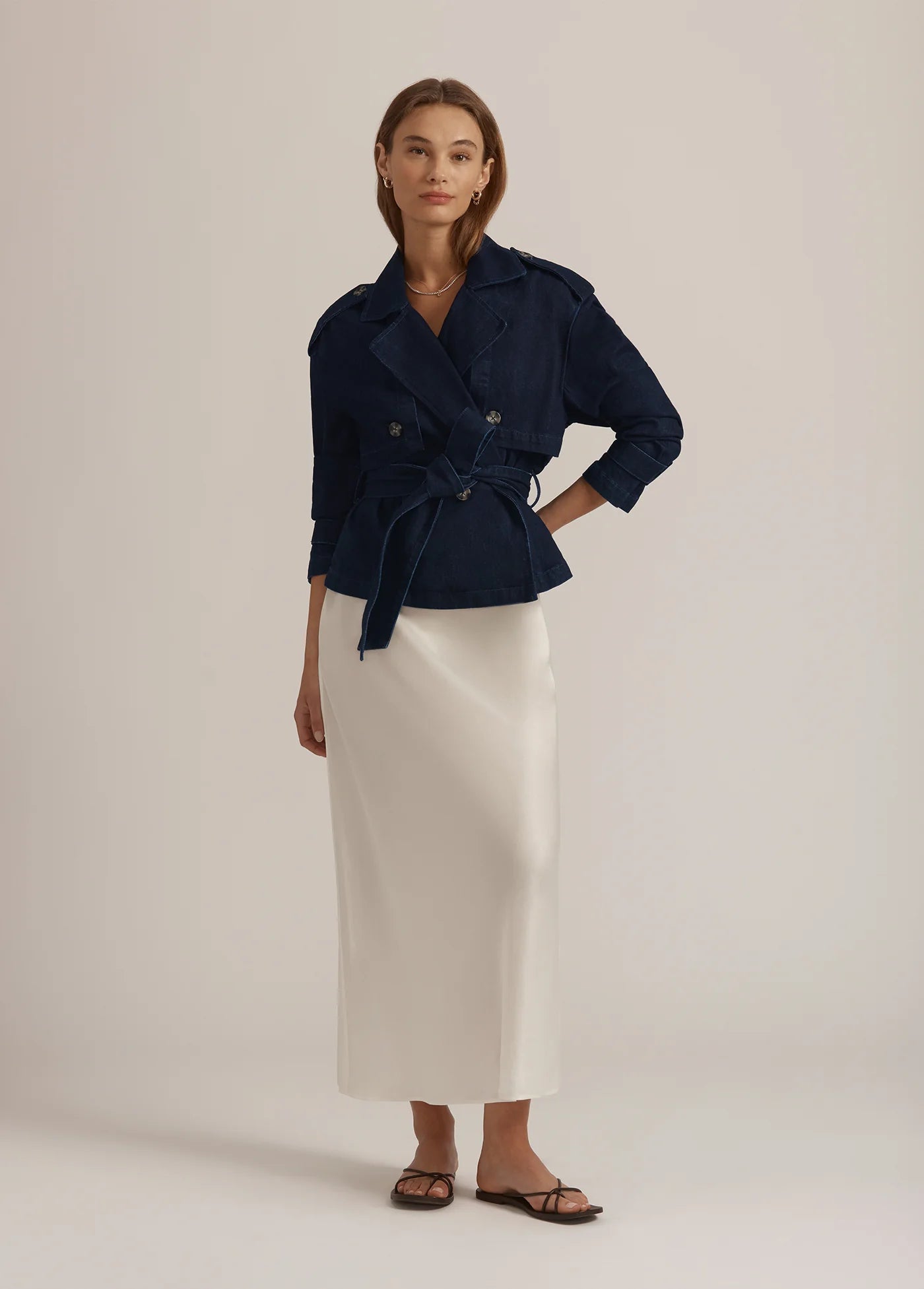 Woman wearing the cropped Charles favourite daughter Lisbon navy blue jacket and white skirt on a plain background.shop online 
