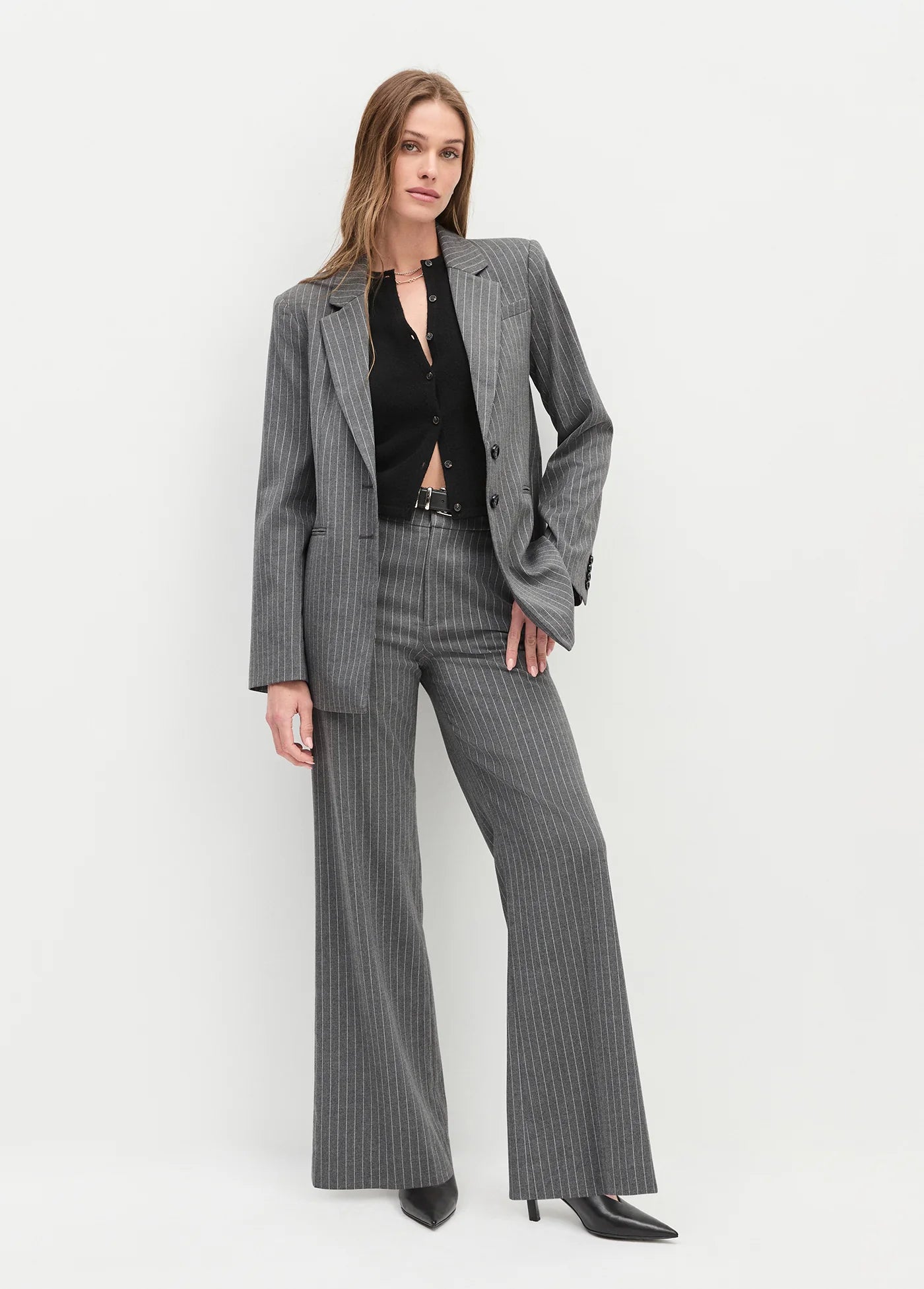 Woman wearing a gray pinstripe suit on a white background